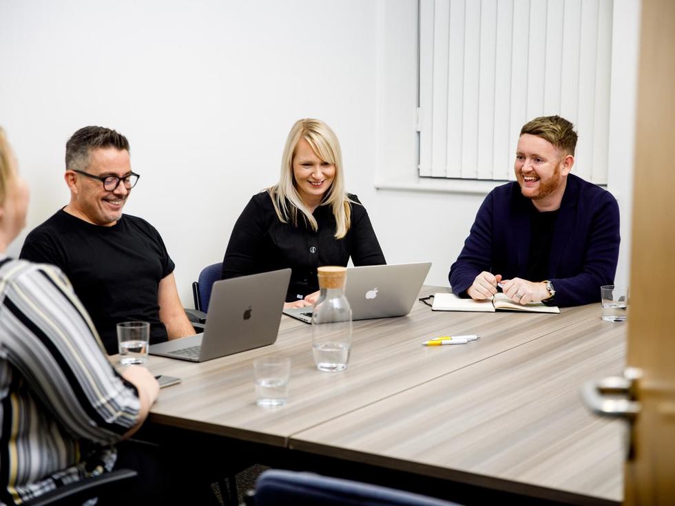 The Seren team working together around a meeting table.